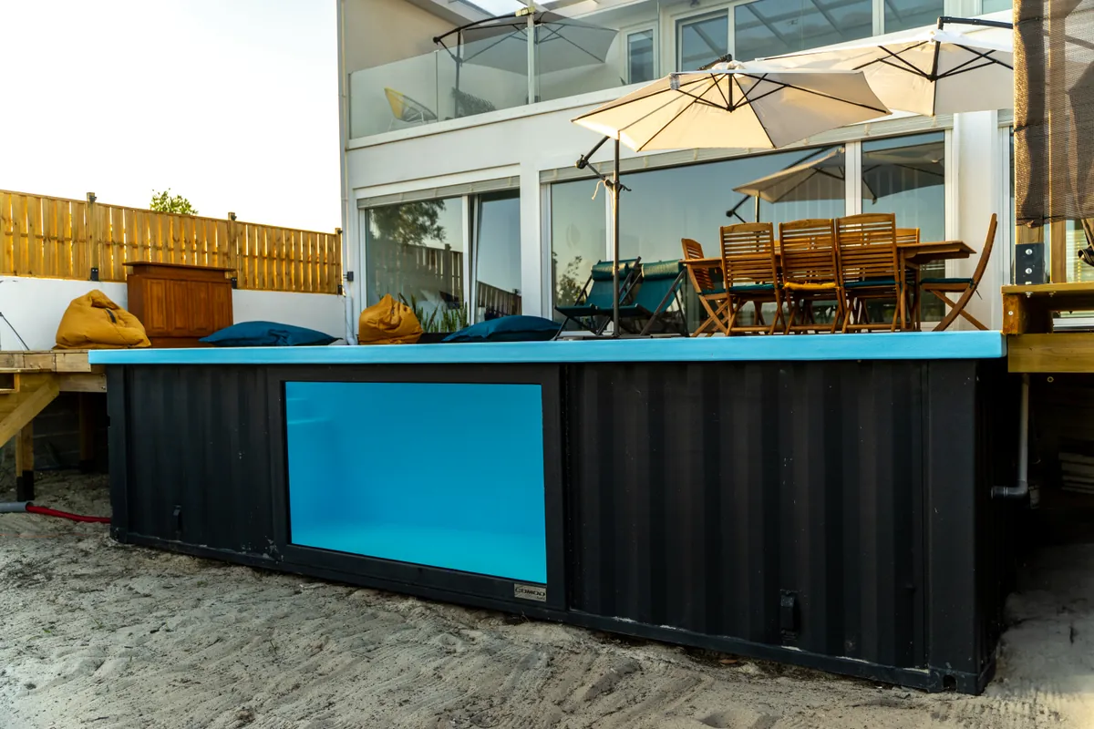 Piscina em contentor antracite com janela panorâmica lateral na Casa Aveiro