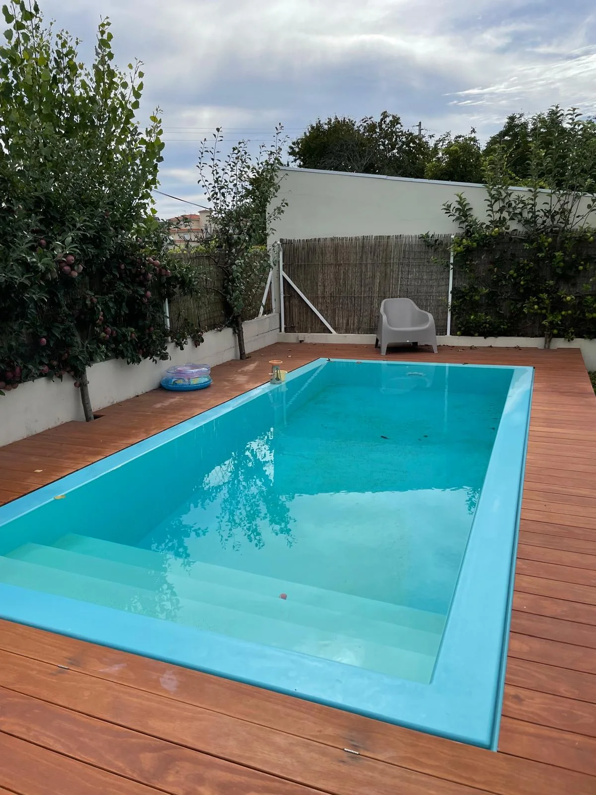 Escadas submersas e deck em redor de uma piscina no jardim